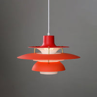 Bright red layered pendant light with illuminated stacked shades and a modern sculptural silhouette.