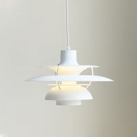 Close-up of a white layered pendant light with softly illuminated stacked shades.