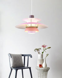 Pink layered pendant light displayed in a cozy corner with a chair and decorative flowers, adding a soft modern touch.