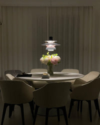 Modern black pendant light with layered shades installed above a dining table, creating an elegant focal point in a contemporary dining interior.