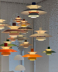 Multiple colorful layered pendant lights hanging in a modern interior space, creating a vibrant lighting installation.