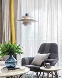 Colorful pendant light installed in a modern living room with a lounge chair, coffee table, and natural decor elements.