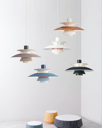 Multiple colorful pendant lights hanging together with layered shades, creating a stylish lighting display in a modern interior.